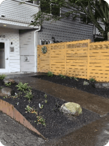 Modern residential front yard with wooden privacy fence and sustainable landscaping in Seattle